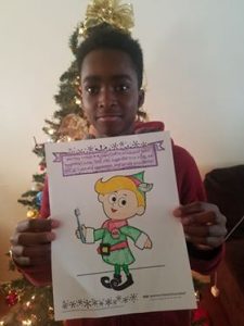 Boy holding colored picture of Hermey the Elf.